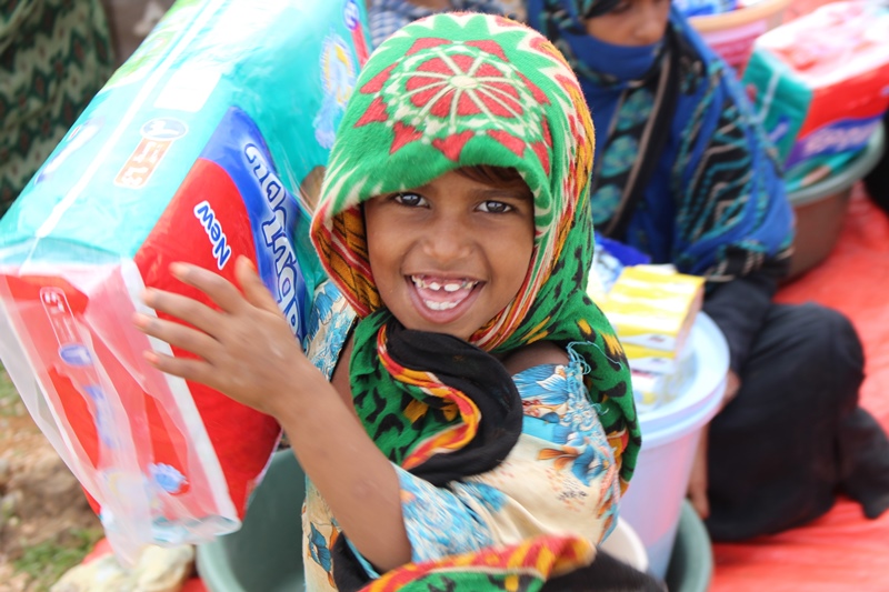 A young girl from Socotra holds up an item from her hygiene pack